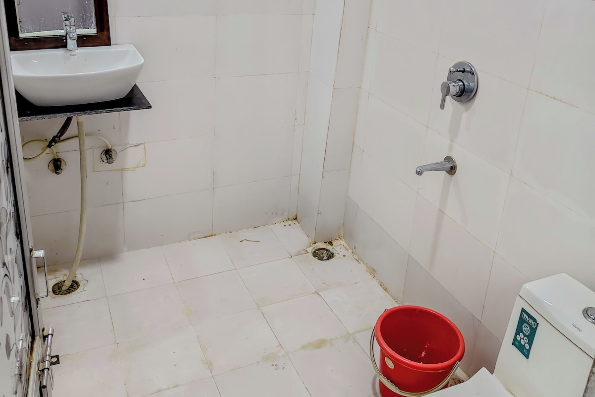 A bathroom with a white sink, a mirror, a shower, and a toilet.