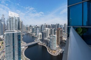 A high-rise building overlooking a cityscape with a river and modern architecture. - Sleek 1BR at Dubai Marina (Dubai)