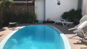 A swimming pool with lounge chairs and potted plants. - Duplex Apartment 5 with 2 Suites 450m from the Beach in Santa Cruz Cabrália (Santa Cruz Cabrália)