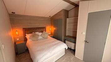 Ein Schlafzimmer mit Bett, Nachttischen, einem Kleiderschrank und einer Tür.