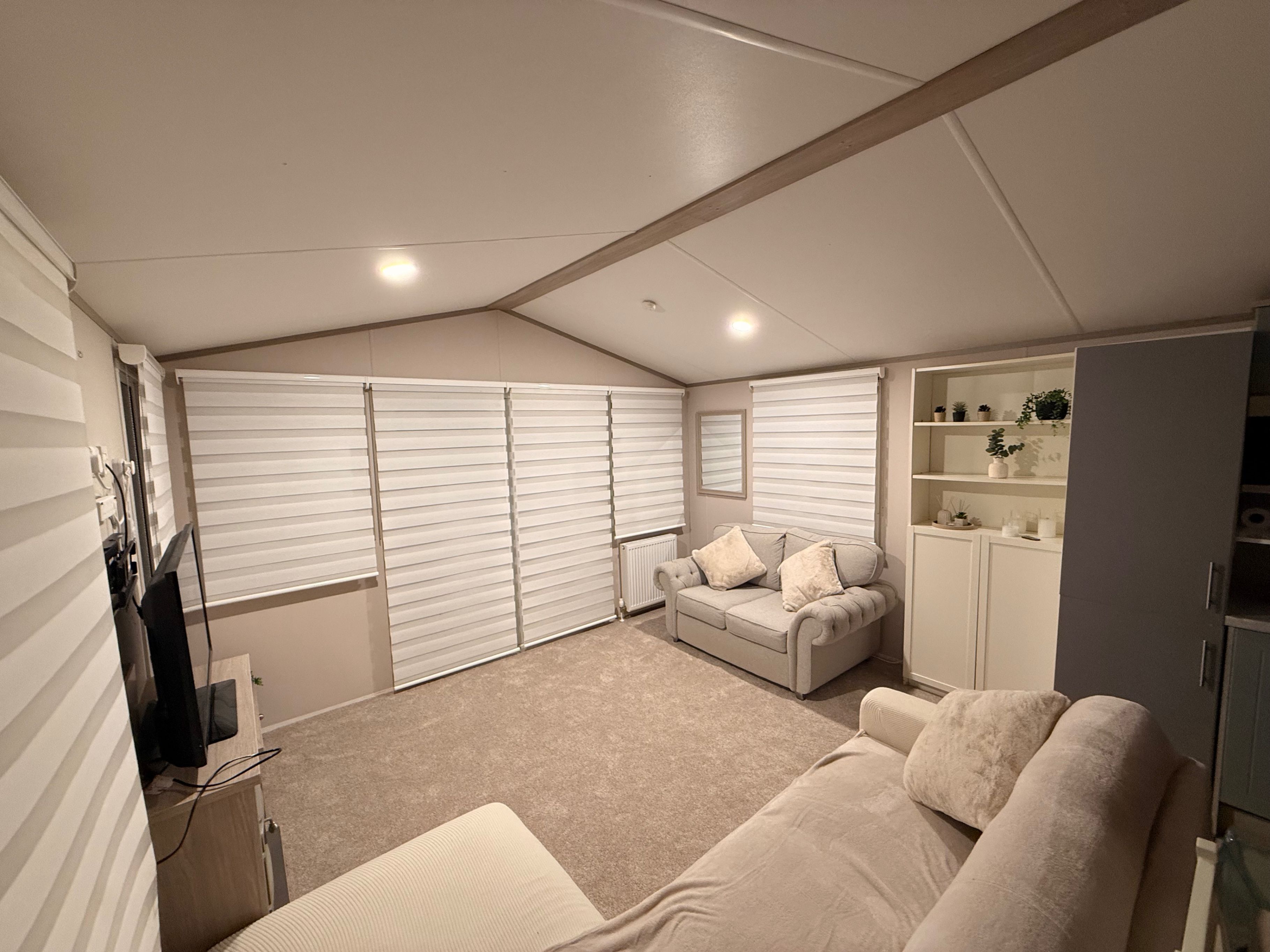 A bedroom with a bed, a sofa, a wardrobe, and a radiator.