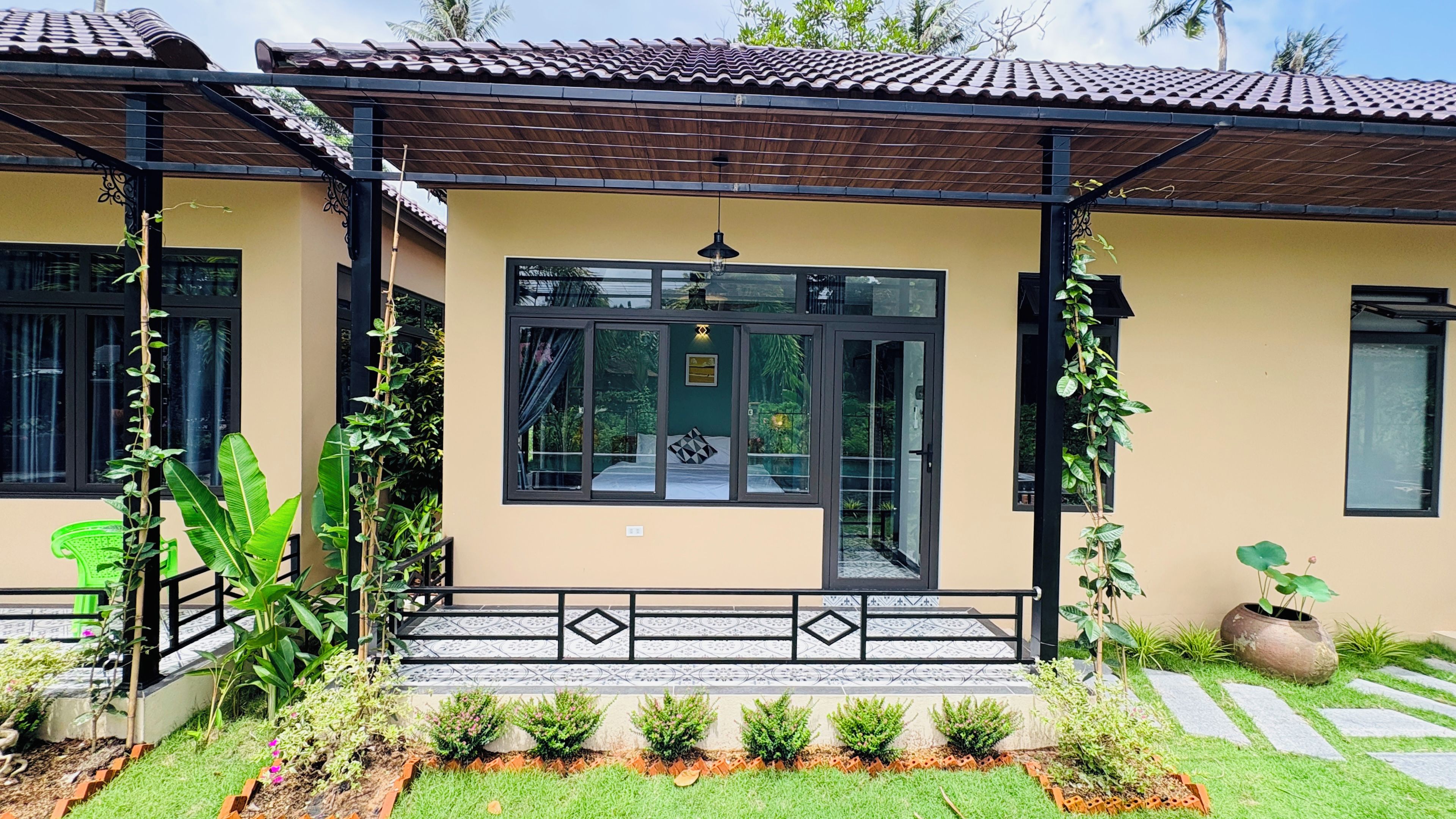 A two-story building with a tiled roof, a balcony, and a large glass door.