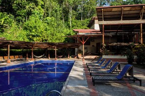 A pool area with lounge chairs and a covered seating area. - Itamandi Eco Lodge (Ahuano)