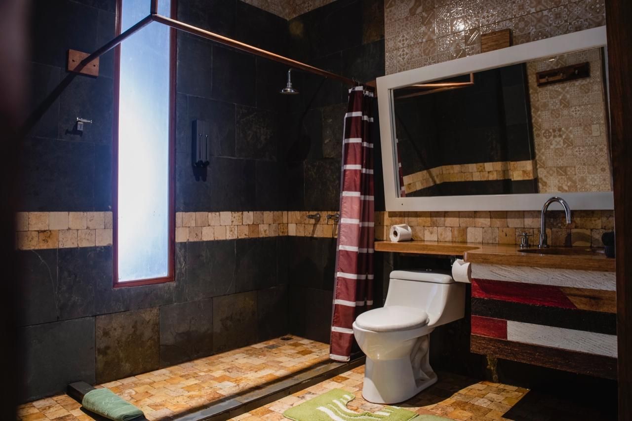 A bathroom with a shower, toilet, and sink.