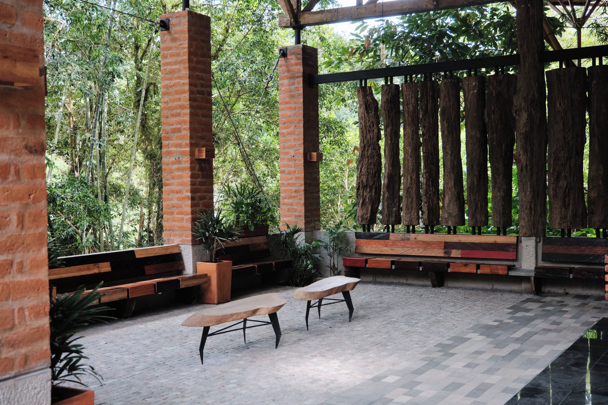 An outdoor seating area with benches and a brick column structure.