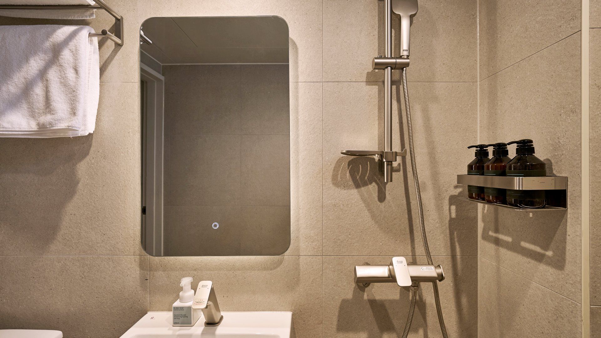 Un baño con ducha, inodoro y toallero.