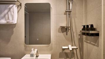 Un baño con ducha, inodoro y toallero.