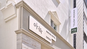 Un cartell d'hotel amb el nom 'ANOOK HOTEL' i 'DAEGU' que indica la ubicació.