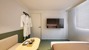 A hotel room with a bed, a sofa, a TV mounted on the wall, and a door. - Anook Hotel Daegu Station (Daegu)