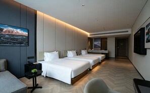 Une chambre d’hôtel avec un grand lit, un bureau, une chaise et un tableau au mur.