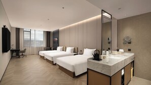 A hotel room with two beds, a desk, a chair, a large mirror, and a bathroom with a marble sink. - Wanda Yi Sayram Lake (Bole)