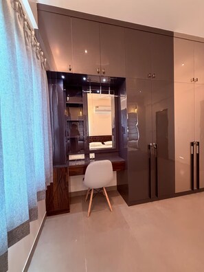 Ein modernes Schlafzimmer mit großem Kleiderschrank, Schreibtisch und Stuhl sowie einem Bett.