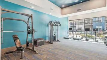 A gym with a pull-up bar, weight bench, and various exercise machines.