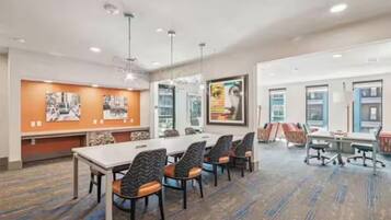 A conference room with a long table, multiple chairs, and artwork on the walls.