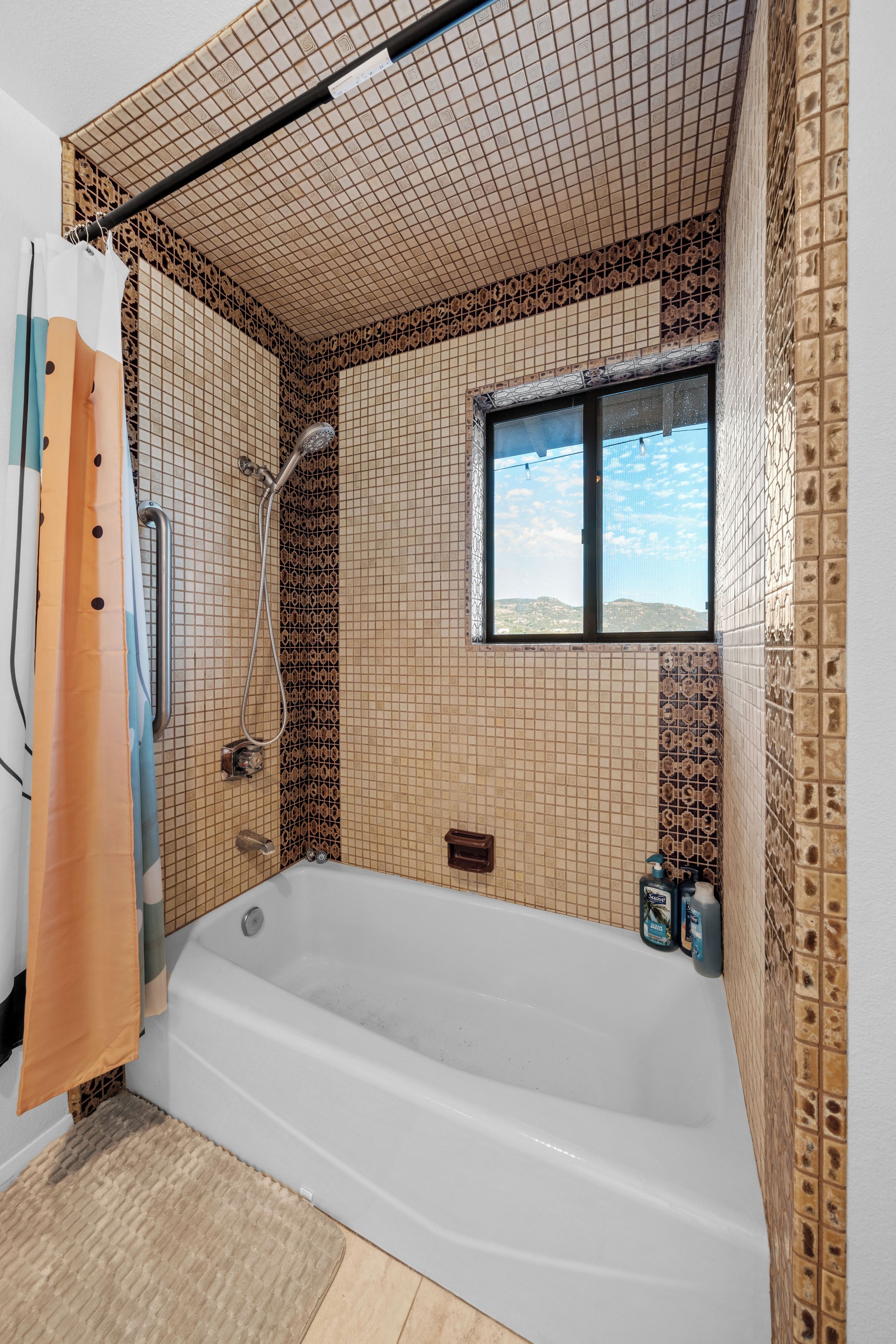 Une salle de bain avec une baignoire, une douche et une fenêtre.