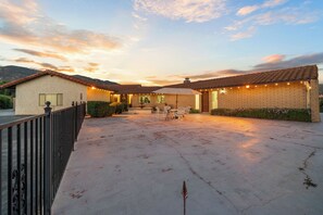 A residential property with a patio area, outdoor seating, and string lights.