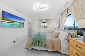 A bedroom with a bed, a window with curtains, a bedside table, and a wall-mounted TV. - Mountain View, 2500 sqft, King Bed, Garage, 3BR/2Bth (Jamul)