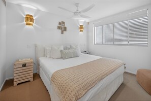 A bedroom with a bed, a wooden nightstand, a ceiling fan, and a window with blinds. - Soul@Sunshine - Private Pool, Ocean View (Sunshine Beach)
