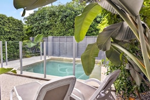 A swimming pool with lounge chairs, surrounded by a fence and lush greenery. - Soul@Sunshine - Private Pool, Ocean View (Sunshine Beach)