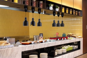 A buffet setup with various food items and utensils.
