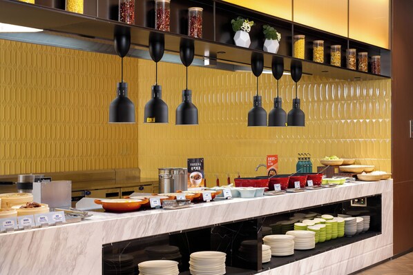 A buffet setup with various food items and utensils.