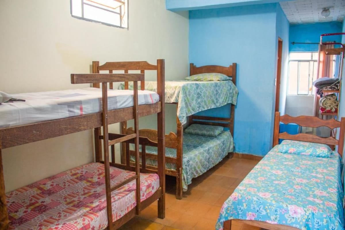 Une chambre de dortoir avec des lits superposés, une fenêtre et un lit superposé avec une échelle.