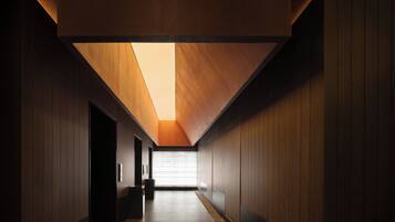 A corridor with wooden panel walls and a sloped ceiling.