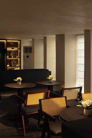 A modern interior with round tables, wicker chairs, and a bookshelf. - Ufeel Hotel Canton Tower & Pazhou Branch (Guangzhou)