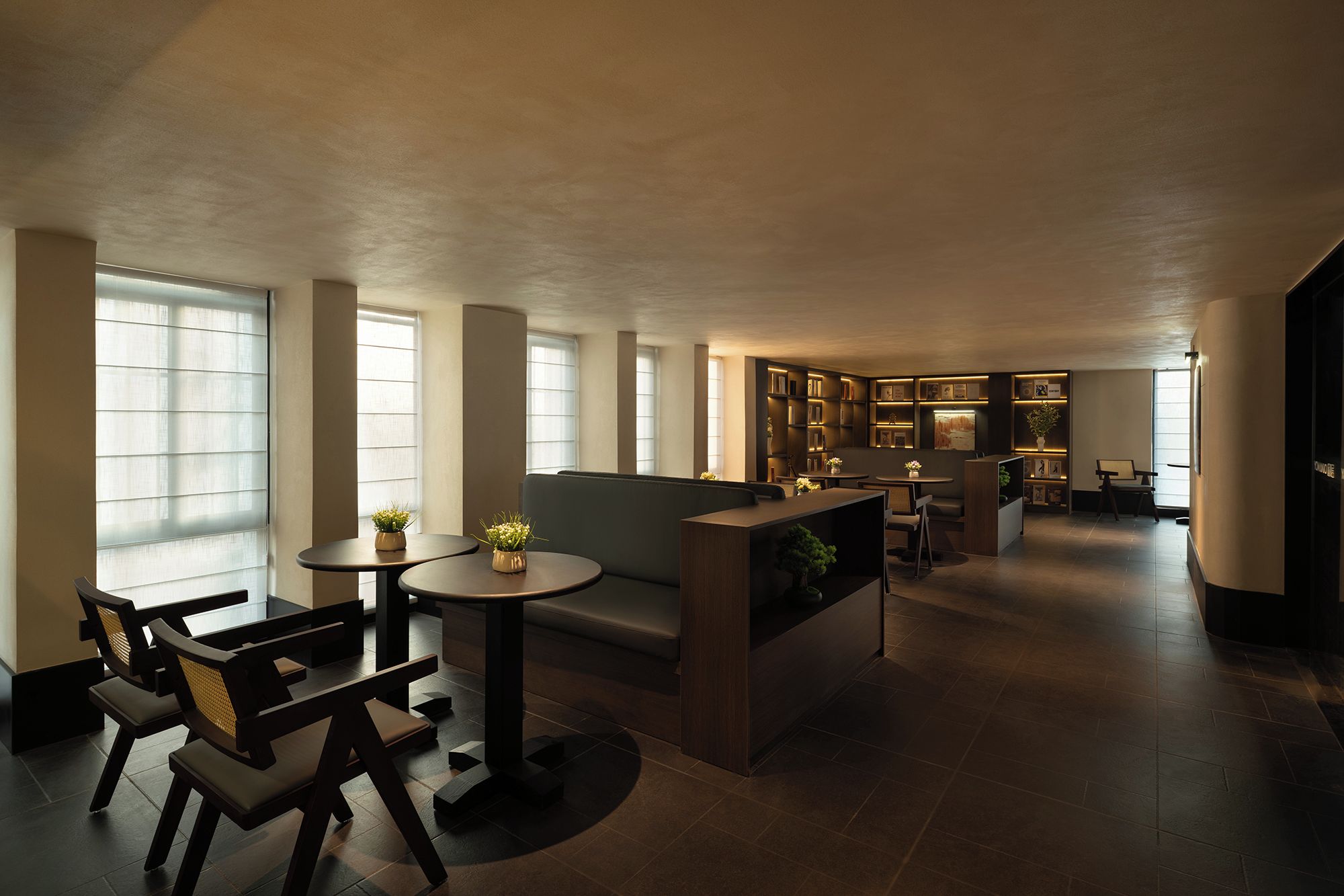 A modern interior with a dining area, seating, and a bookshelf.