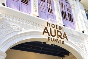 Een hotelsbord met de naam 'hotel AURA PURVIS' in een klassieke architectuur met decoratieve details.