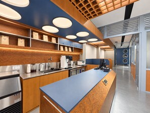Een moderne keuken met een centraal eiland, roestvrijstalen apparatuur en houten keukenkastjes.