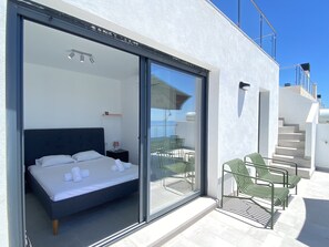 A modern bedroom with a bed, a nightstand, and a chair. - Penthouse in Malaga With Sea View Terraces (Nerja)