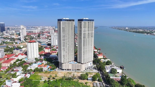 A high-rise building with a modern architectural design, surrounded by a coastal cityscape.