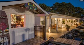 A waterfront property with a bar area, outdoor seating, and a covered patio.