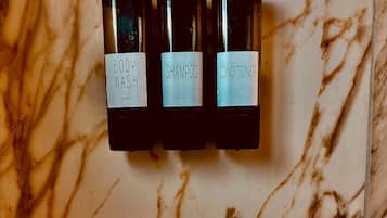 Three bottles with labels on a marble surface.
