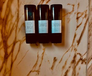 Three bottles with labels on a marble surface.