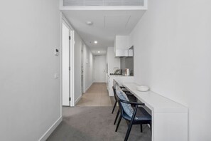 A narrow hallway leading to a kitchen with a dining area. - The Southbank King - Pool, Gym and Tram, near CBD (Southbank)