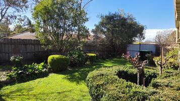 A well-maintained garden with a variety of shrubs and a neatly trimmed lawn.