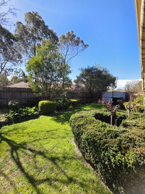 A well-maintained garden with a variety of shrubs and a neatly trimmed lawn. - 🌿 Private Queen Bedroom, Private Bathroom & Garden Retreat in Sunbury (Sunbury)