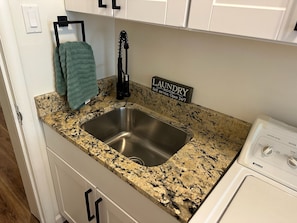 A kitchen with a granite countertop, stainless steel sink, and a Kenmore washer. - 3-Bedroom Ponderosa Paradise at 6,398 feet. Beautifuly cool. (Prescott)