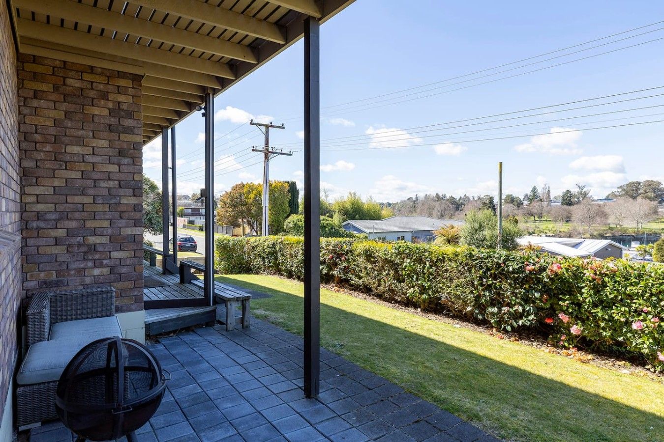 A covered outdoor area with a brick wall, a bench, and a table.