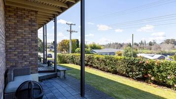 A covered outdoor area with a brick wall, a bench, and a table.