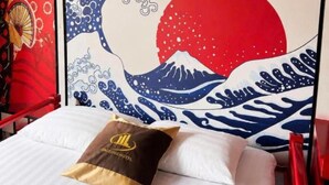 A bed with a pillow, a wall with a Japanese wave painting, and a red headboard. - HOANG LONG 1 HOTEL (Hanoi)