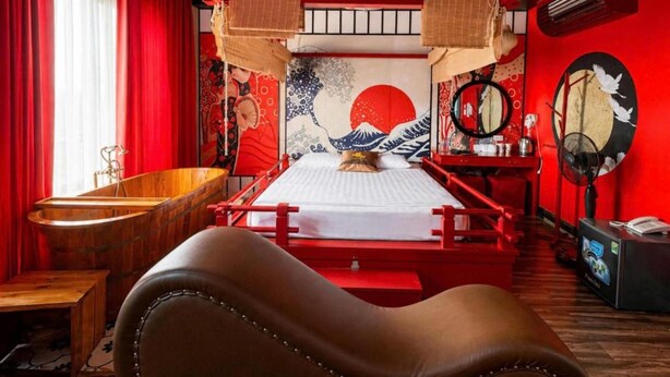 A room with a bed, a wooden bathtub, and a red and black color scheme. - HOANG LONG 1 HOTEL (Hanoi)