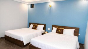 Two single beds with wooden headboards and white bedding, in a room with blue walls and a tiled floor. - HOANG LONG 1 HOTEL (Hanoi)