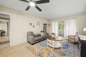A living room with a grey sofa, a round coffee table, and a patterned rug. - Paradise Pkwy Getaway in Phoenix + Pool (Phoenix)
