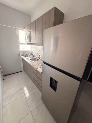 A kitchen with a stainless steel refrigerator, a microwave, and a gas stove. - Acapulco shines! Beautiful apartment. Just 15 minutes from Puerto Márquez and P. Diamante (Acapulco de Juárez)