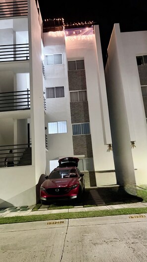 A modern building with a red car parked in front. - Acapulco shines! Beautiful apartment. Just 15 minutes from Puerto Márquez and P. Diamante (Acapulco de Juárez)