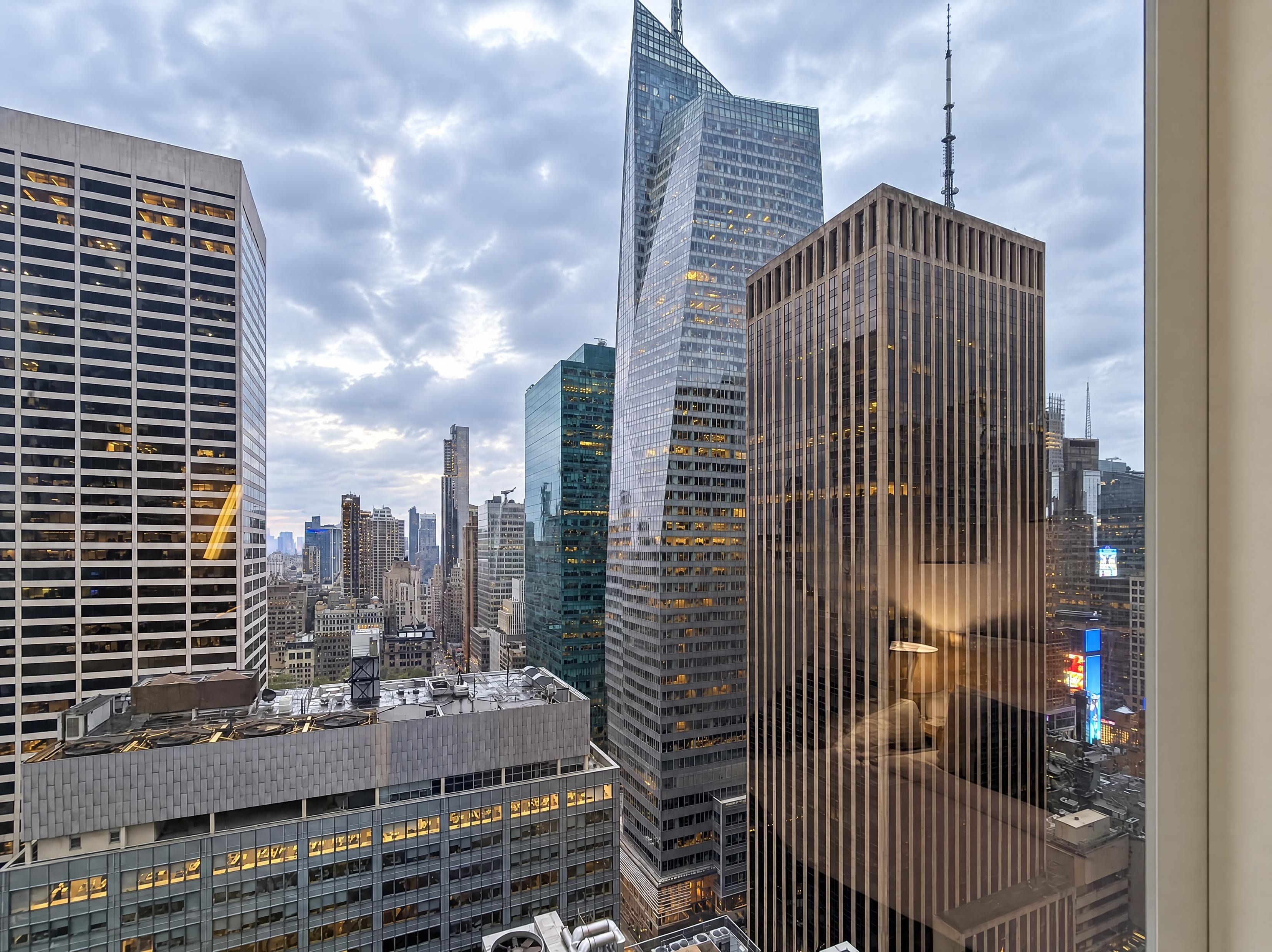 Un paysage urbain avec des immeubles modernes de grande hauteur, dont un gratte-ciel à la forme incurvée particulière.