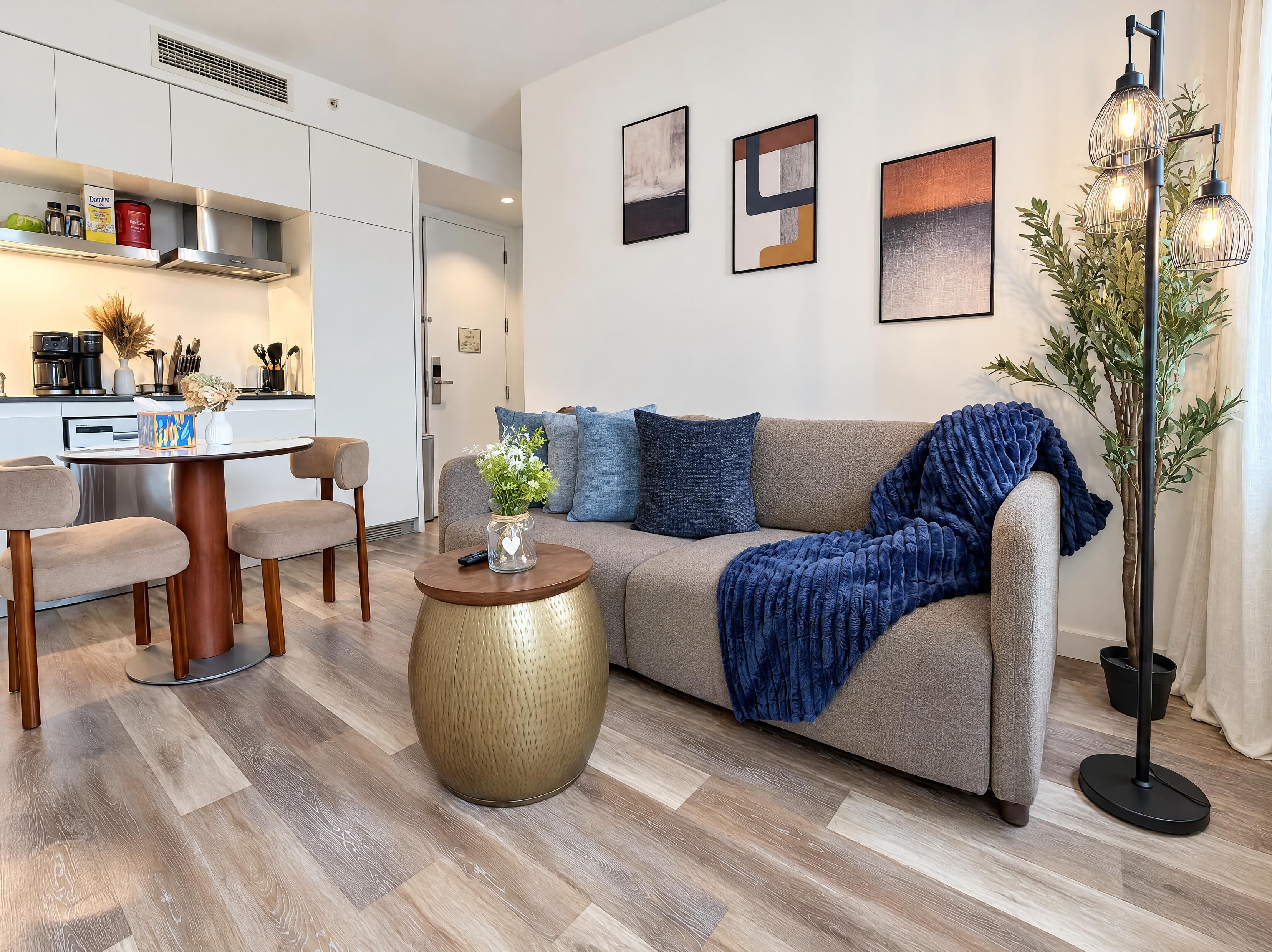 A modern living room with a sofa, coffee table, and a dining area with chairs.